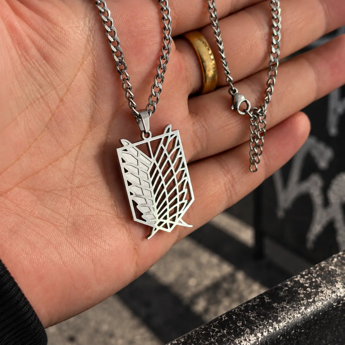 Survey Corps Stainless Steel Necklace from anime Attack On Titan held by hand