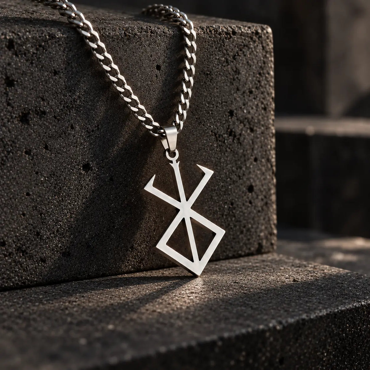 Brand Of Sacrifice Stainless Steel Necklace from Anime Berserk displayed on a stone