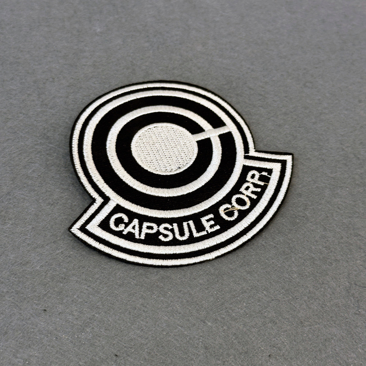 Detail of Capsule Corp embroidered patch showing textured stitching – anime patch – Akira Gallery
