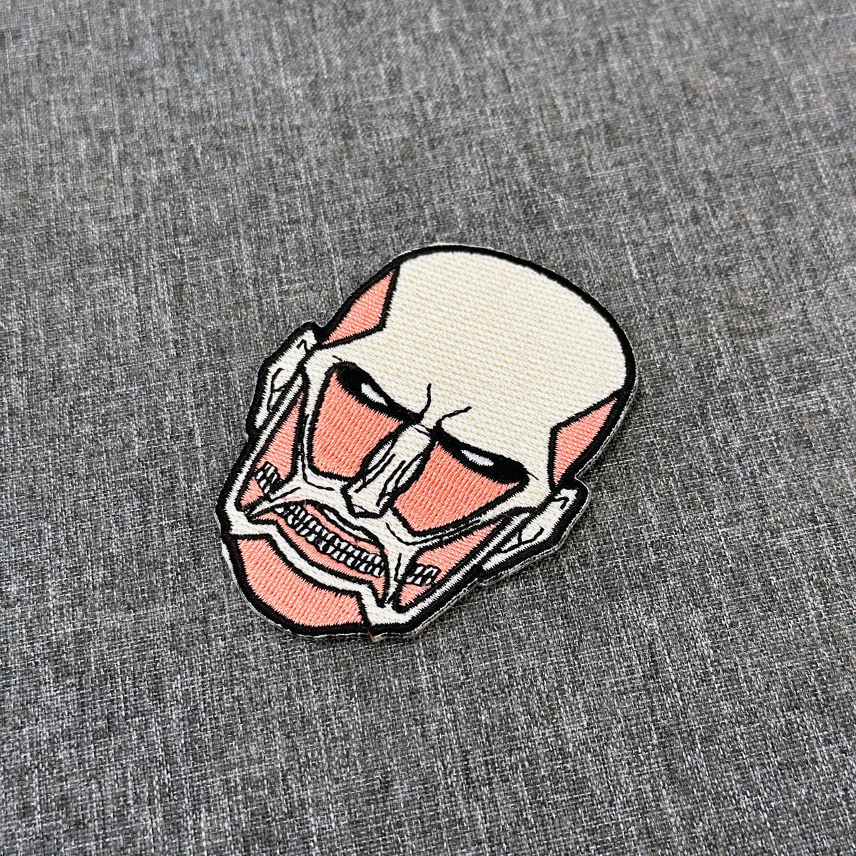 Detail of Colossal Titan embroidered patch showing textured stitching – anime patch – Akira Gallery
