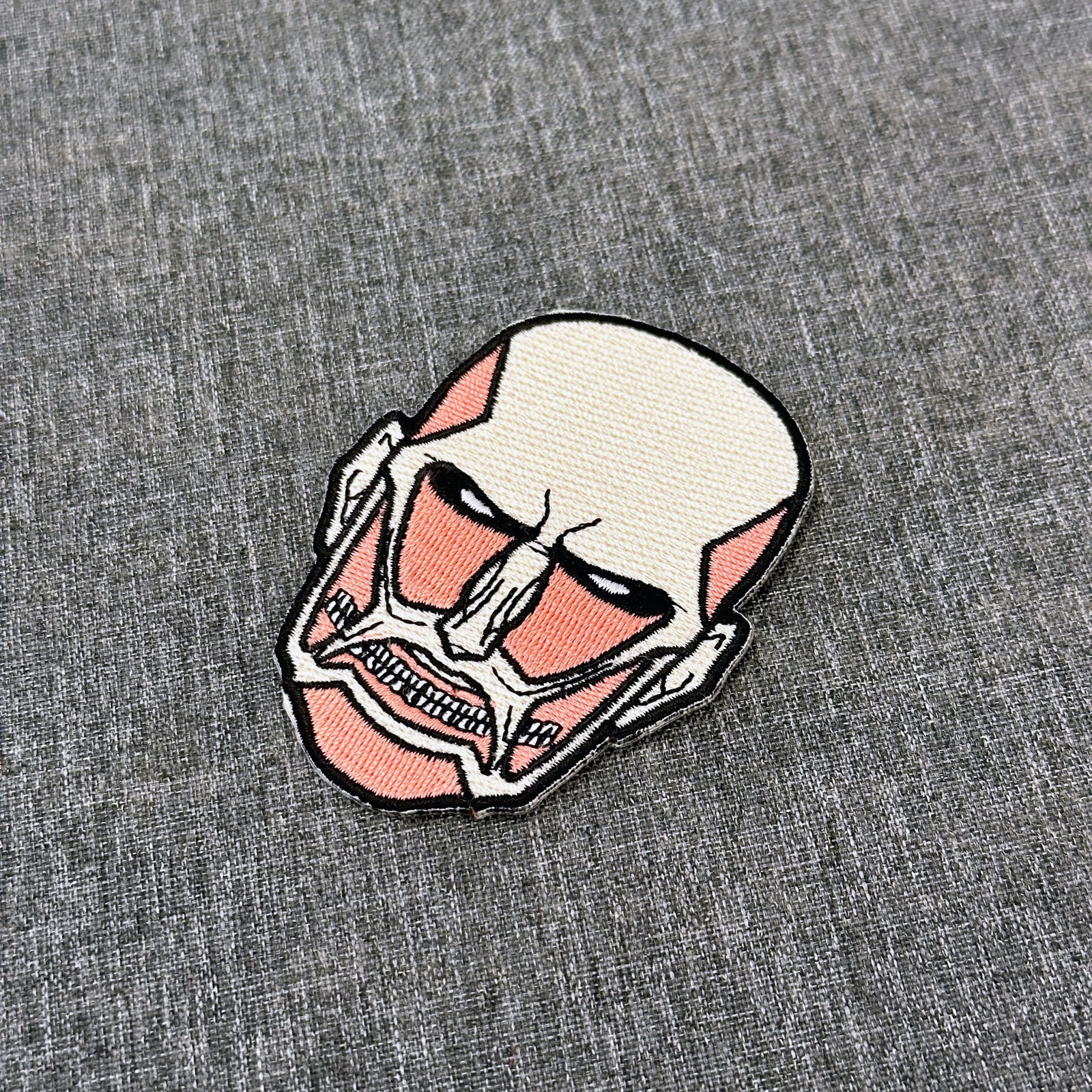 Detail of Colossal Titan embroidered patch showing textured stitching – anime patch – Akira Gallery

