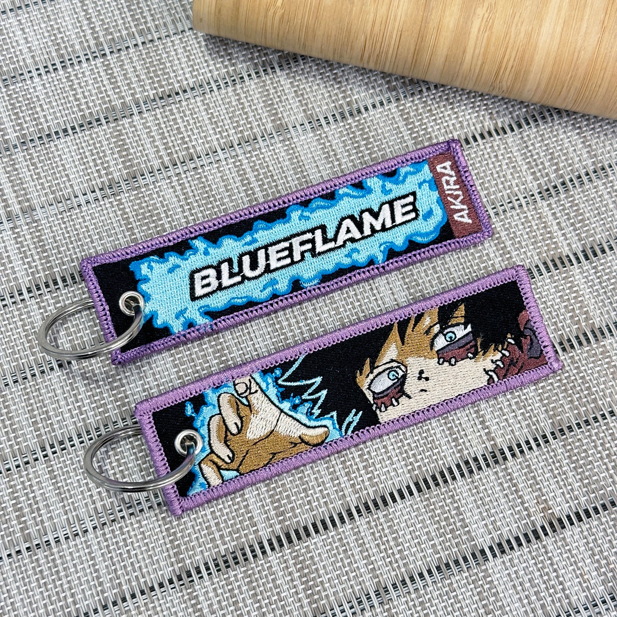 Double-sided embroidered keychain of Dabi from My Hero Academia. One side features the word "Blueflame" with a red "AKIRA" label, and the other side shows Dabi's face and raising his hand