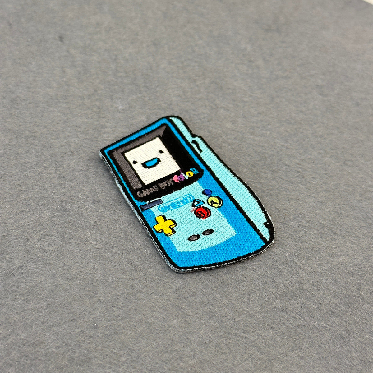 Detail of GBC x BMO embroidered patch showing textured stitching – crossover anime patch – Akira Gallery
