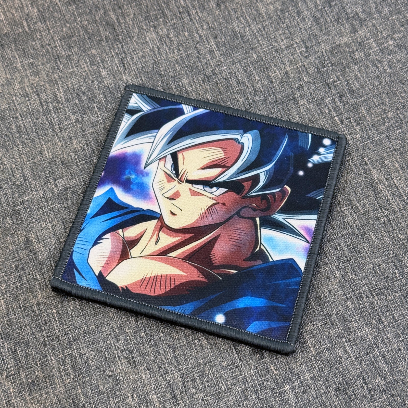 Display of Goku Ultra Instinct sublimated anime patch inspired by Dragon Ball with velcro backing – Akira Gallery

