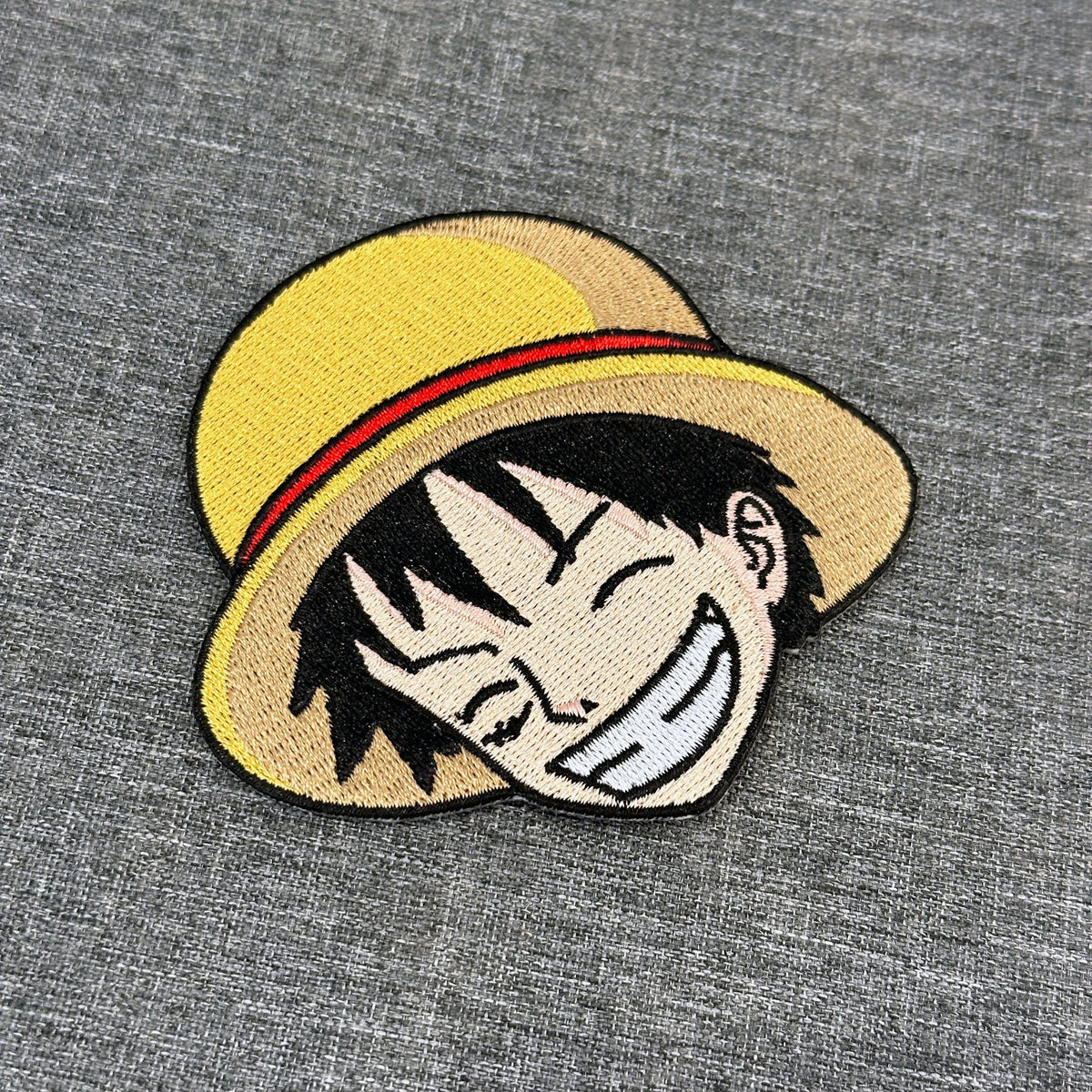 Display of Luffy embroidered patch showing textured stitching – One Piece anime patch – Akira Gallery
