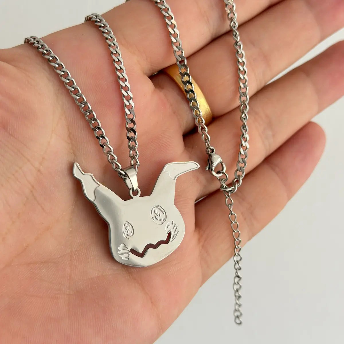 Mimikyu Stainless Steel Necklace from anime Pokemon held by hand