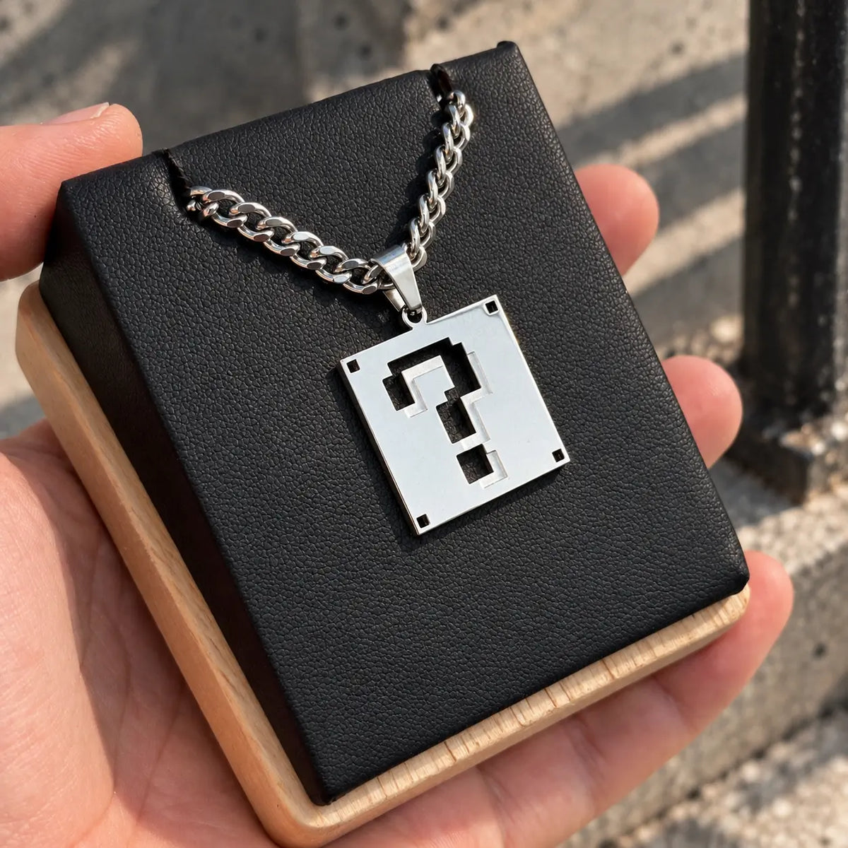 Super Mario Stainless Steel Necklace featuring the question block displayed on a black block