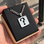 Super Mario Stainless Steel Necklace featuring the question block displayed on a black block