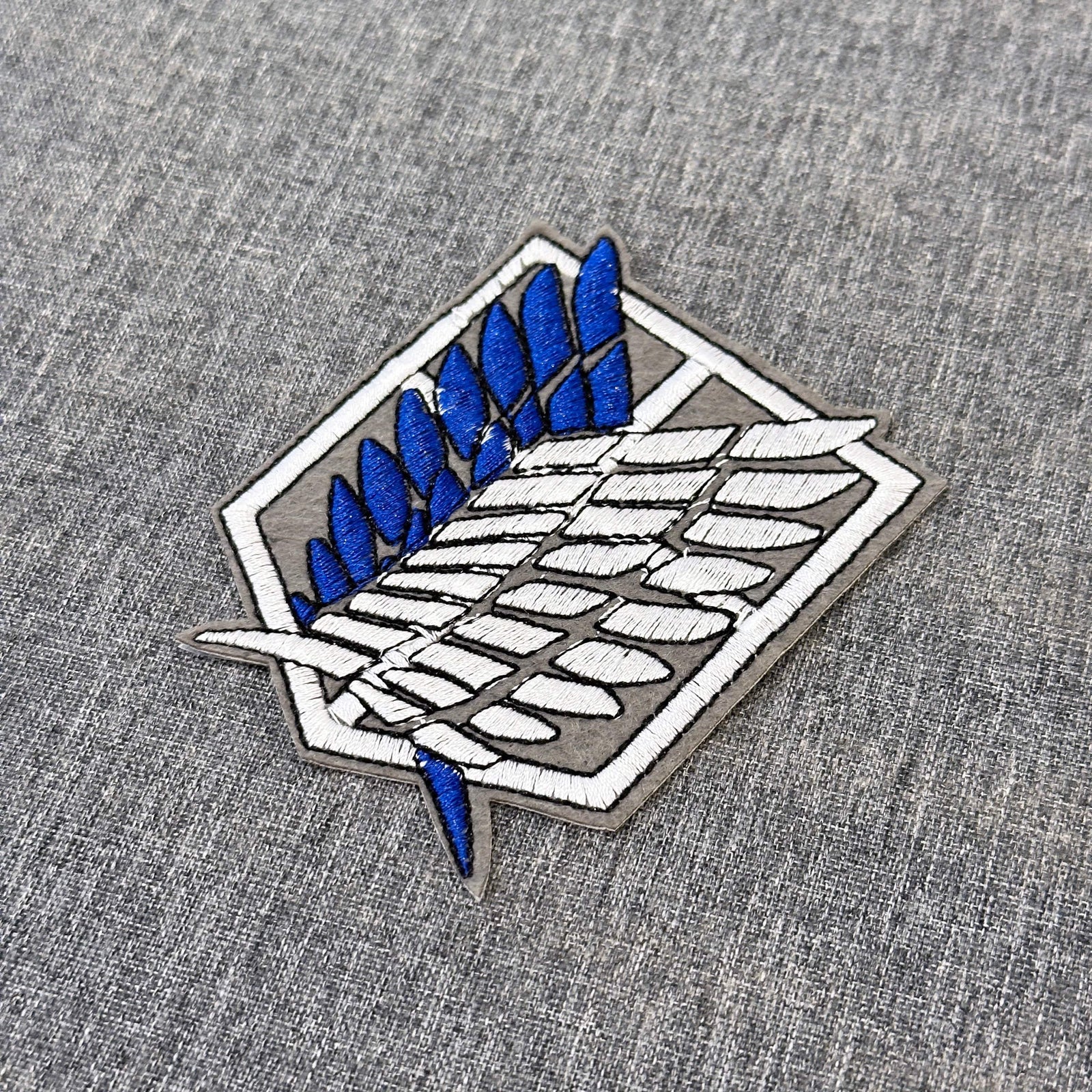 Detail of Survey Corps emblem embroidered patch showing textured stitching – anime patch – Akira Gallery
