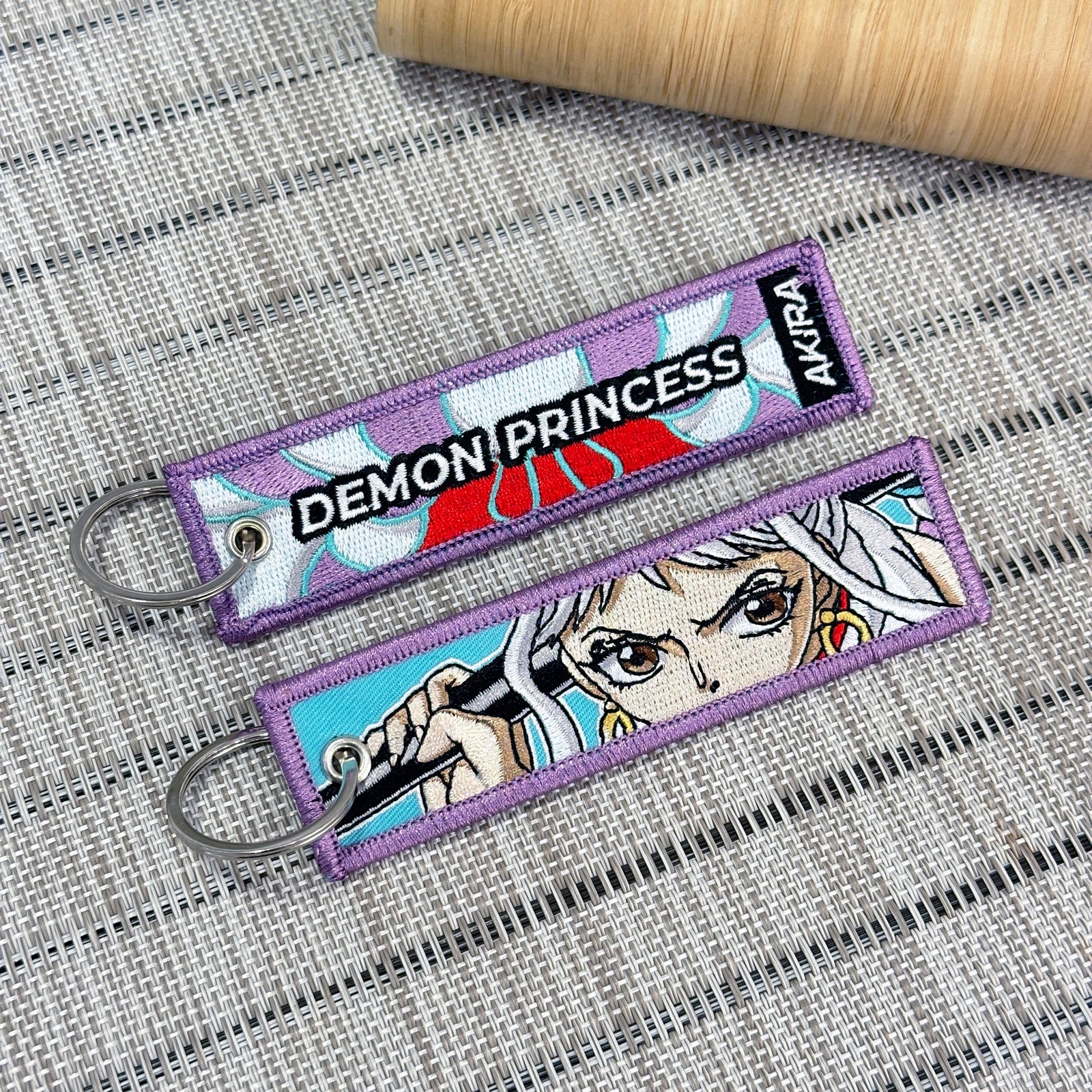 Double-sided embroidered keychain of Yamato from One Piece. One side features the words "Demon Princess" with her kimono pattern, and the other side shows Yamato holding her weapon "Takeru"