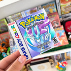Pokémon Crystal Version sticker with Suicune held in front of a retro Pokémon game collection