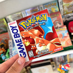 Pokémon Red Version sticker with Charizard held in front of a retro Pokémon game collection