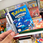 Pokémon Sapphire Version sticker with Kyogre held in front of a retro Pokémon game collection